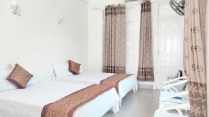 um quarto com duas camas e uma cadeira em Khách sạn Đại Huệ em Dong Quan