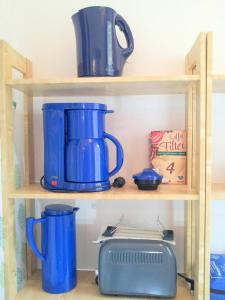 a shelf with blue pots and pans and a toaster at Ferienwohnung am Ellerbach in Hessisch Oldendorf