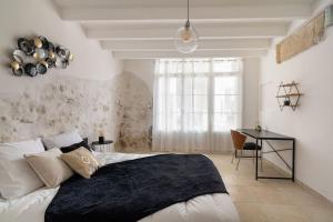 a bedroom with a bed and a desk in it at Évasion de charme, maison authentique et spa privé in La Baume-de-Transit