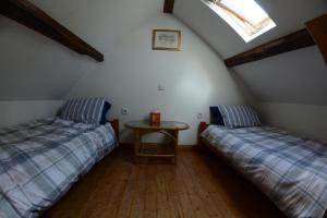 a attic room with two beds and a table at La Paisière in Montaudin