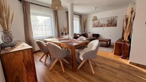 een woonkamer met een houten tafel en stoelen bij Villa Vita Hegykő in Hegykő