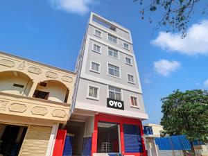 OYO Hotel Shannu Grand في حيدر أباد: مبنى رمادي طويل مع علامة اكسو عليه