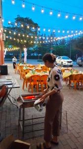 uma mulher em pé em frente a uma mesa com uma grelha em Khách sạn Đại Huệ em Dong Quan