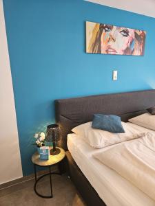 una camera con un letto con una parete blu di Motel24seven a Bruck an der Mur