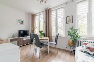 Una cocina y una sala de estar con mesa y sillas. en Szeroka Royal Rooms, en Gdansk