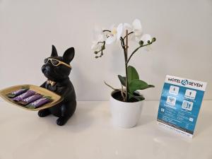 a black cat figurine next to a plant and a box at Motel24seven in Bruck an der Mur
