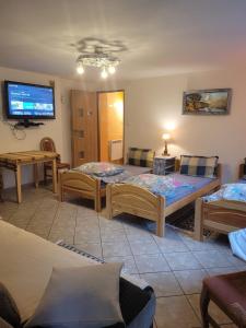 a room with three beds and a flat screen tv at Agroturystyka Oblica in Zawoja