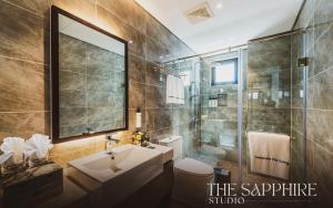 a bathroom with a sink and a shower at The Sapphire Ha Long in Ha Long