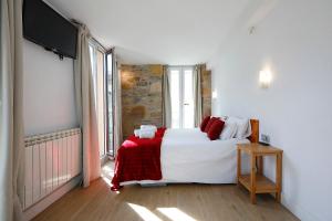 1 dormitorio con 1 cama grande y TV en Pensión Balerdi Autocheck-in, en San Sebastián