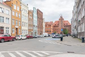 a city street with cars parked on the street at Szeroka Royal Rooms in Gdańsk