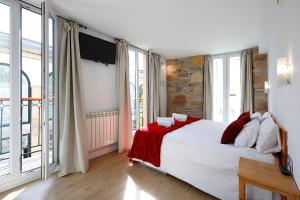 ein Schlafzimmer mit einem großen Bett mit roten und weißen Kissen in der Unterkunft Pensión Balerdi in San Sebastián