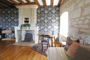a living room with a fireplace and a stone wall at Jallanges in Fontevraud-l'Abbaye