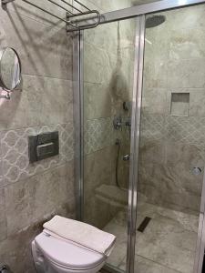 a bathroom with a glass shower with a toilet at Tiana Butik Otel in Bodrum City