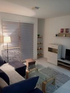 Grandeur Home Apartment Mostar في موستار: غرفة معيشة مع أريكة وطاولة زجاجية