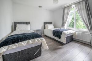 a bedroom with two beds and a window at Spacious Worcester City Centre House in Worcester