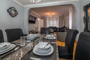 a dining room with a table and a living room at Spacious Worcester City Centre House in Worcester