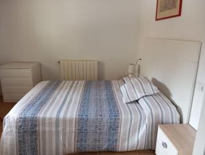 a bedroom with a bed with a striped blanket at Casa Rural - De Brevas a Higos in Espirdo