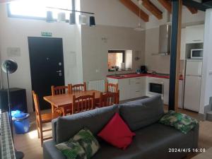 a living room with a couch and a table and a kitchen at Casa Rural - De Brevas a Higos in Espirdo