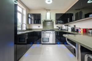 a kitchen with black cabinets and a stove in it at Spacious Worcester City Centre House in Worcester