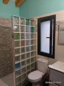 a bathroom with a toilet and a window at Casa Rural - De Brevas a Higos in Espirdo