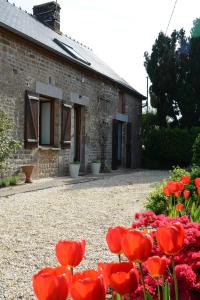 a house with red flowers in front of it at La Paisière in Montaudin