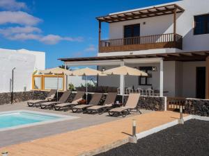 eine Villa mit einem Pool und Liegestühlen in der Unterkunft Villa Palmera La Vegueta Villas in Tinajo