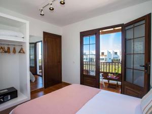 ein Schlafzimmer mit einem Bett und einem Balkon in der Unterkunft Villa Palmera La Vegueta Villas in Tinajo + 27 Fotos