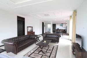 a living room with two leather couches and a television at Vista Valle in Murree