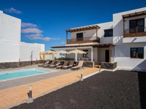 eine Villa mit Swimmingpool und ein Haus in der Unterkunft Villa Palmera La Vegueta Villas in Tinajo