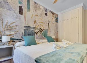 a bedroom with a large bed with blue pillows at Coral Apartment La Cala Beach in La Cala de Mijas