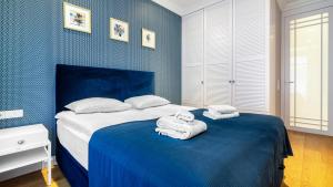 sypialnia z łóżkiem z ręcznikami w obiekcie Prestige Apartments Neptun Park w Gdańsku