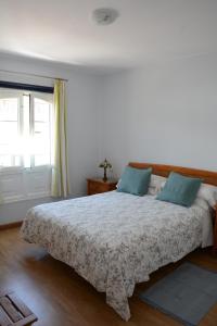 プラヤ・ブランカにあるSounds of The Sea Apartmentのベッドルーム(青い枕の大型ベッド1台付)