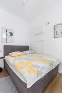 a bed in a bedroom with a white wall at Apartment Modern Studio Near Žnjan Beach in Split