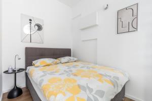 a bedroom with a bed with a floral bedspread at Apartment Modern Studio Near Žnjan Beach in Split