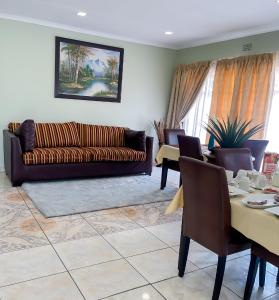 a living room with a couch and a table at Oasis Of Life Guest House in eMalahleni