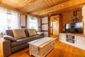 a living room with a couch and a flat screen tv at Schwarzwaldstübchen nähe Europapark in Ettenheim