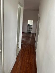 an empty room with a hallway with a wooden floor at 2 bedroom flat Wembley in London