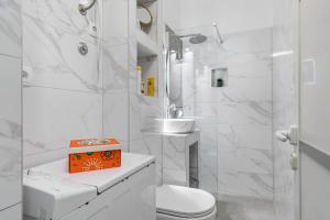 a white bathroom with a toilet and a sink at Apartment Modern Studio Near Žnjan Beach in Split