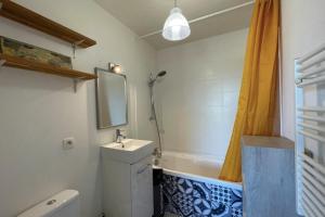 La salle de bains est pourvue d'un lavabo et d'une baignoire. dans l'établissement Nice studio near train station and old port, à La Rochelle