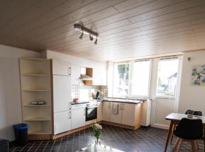 a kitchen with white cabinets and a table and windows at Ferienwohnung für 2 Personen mit direktem Zugang in Auw