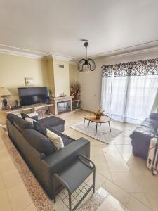 sala de estar con 2 sofás y TV en Villa Algarve- Townhouse in Farm Village, Albufeira, en Albufeira