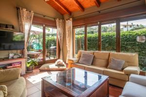 een woonkamer met een bank en een glazen tafel bij Villa La Marquesa de Llanes in Llanes