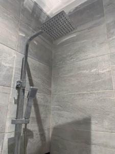 a shower with a shower head in a bathroom at Conys Guest House in Kwabenyan