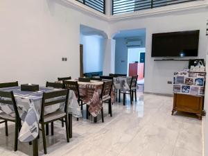 a dining room with tables and chairs and a flat screen tv at Conys Guest House in Kwabenyan