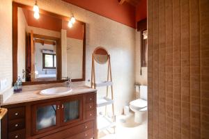 Un baño con lavabo, espejo e inodoro. en Villa La Marquesa de Llanes, en Llanes 34 fotos más