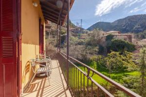 a balcony with a table and a view of a mountain at Το Aρχοντικό των Τσιντζίνων in Polídhroson