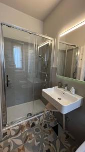 uma casa de banho com um lavatório e uma cabina de duche em vidro. em Serra Country House em Gradara
