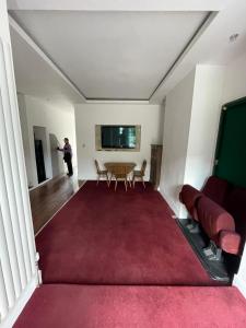 a living room with a table and a red rug at 2 bedroom flat Wembley in London