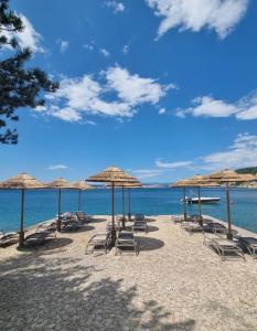 a group of chairs and umbrellas on a beach at Apartman Rene, 150m from the sea, panorama view, Crikvenica, Dramalj, parking in Dramalj