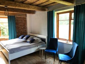 1 dormitorio con 1 cama y 2 sillas azules en Spokojny Zakątek, en Mrągowo